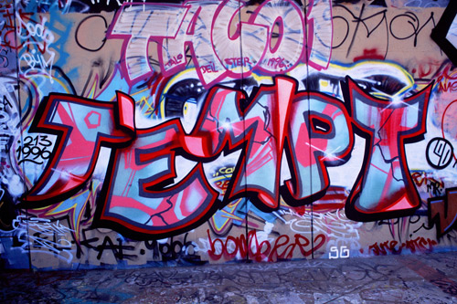 A graffitied wall reaing "Tempt"in pinks, reds, and blues— the name of the graffiti artist who is the subject of the film.