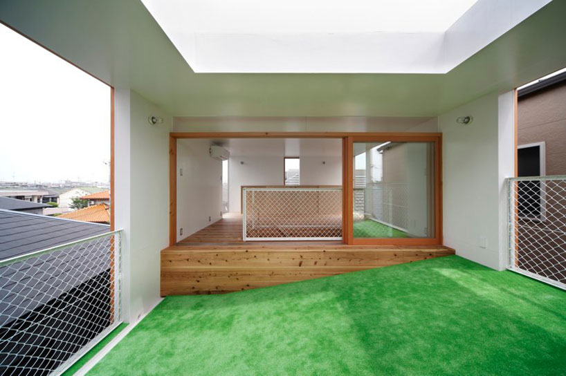 A house in Osaka, where an inclined plane covered in astroturf bridges indoor and outdoor space: windows to the outside on each end of the slope, and a skylight overhead. An invitation to lie on the grass, but with shelter.
