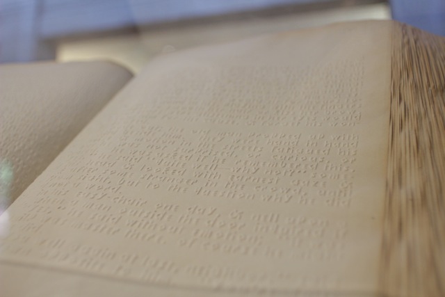 A close up of engraved "Boston Line Type," white raised English language letters, formed with squarish corners for easier identification.