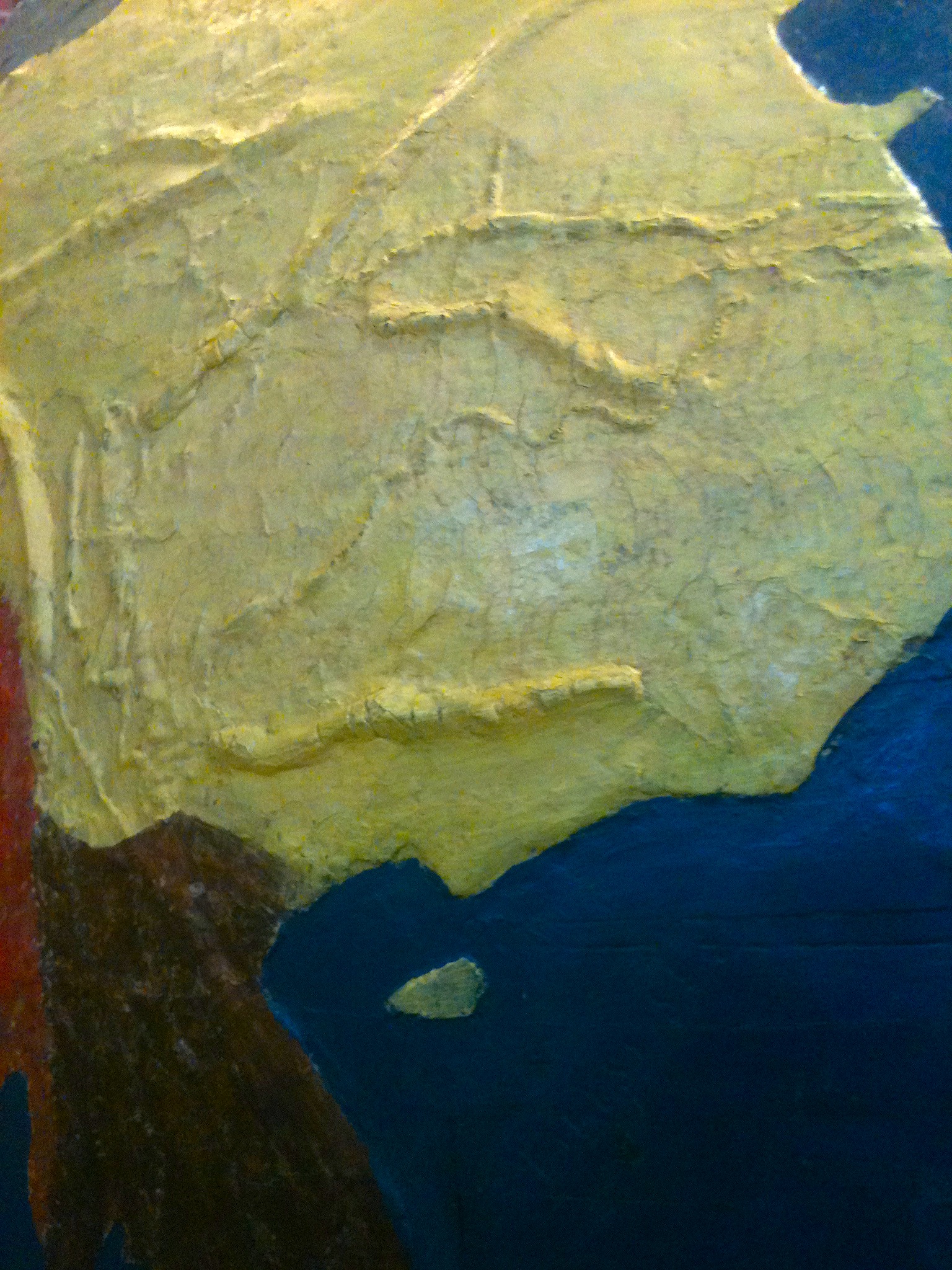 A close-up of the haptic globe, where you can see the cracked paint and palpable ridges of mountain ranges on the surface.