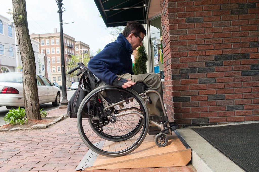 A wheelchair user utilizes my same ramp design for access at a single-step  entrance in Boston.