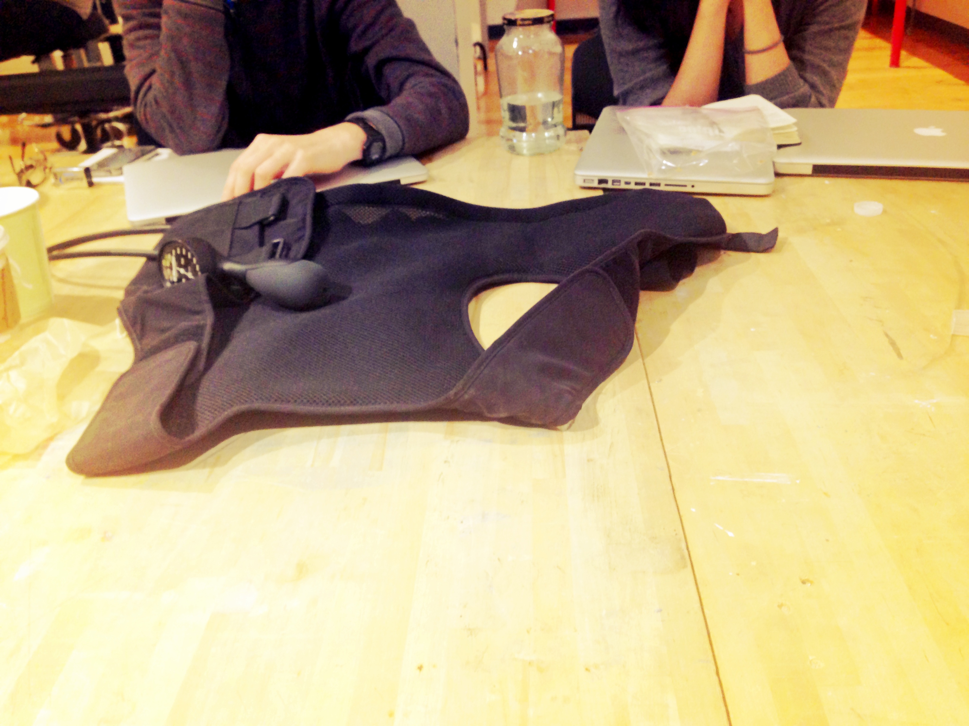 The vest at rest on our classroom table, students around.