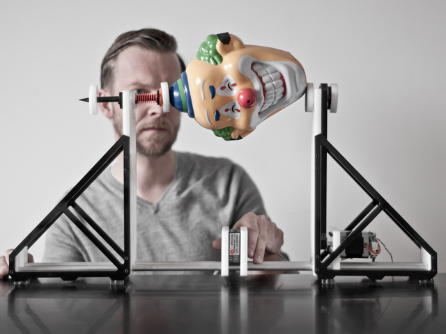 The same instrument, holding a plastic face-sized clown mask.